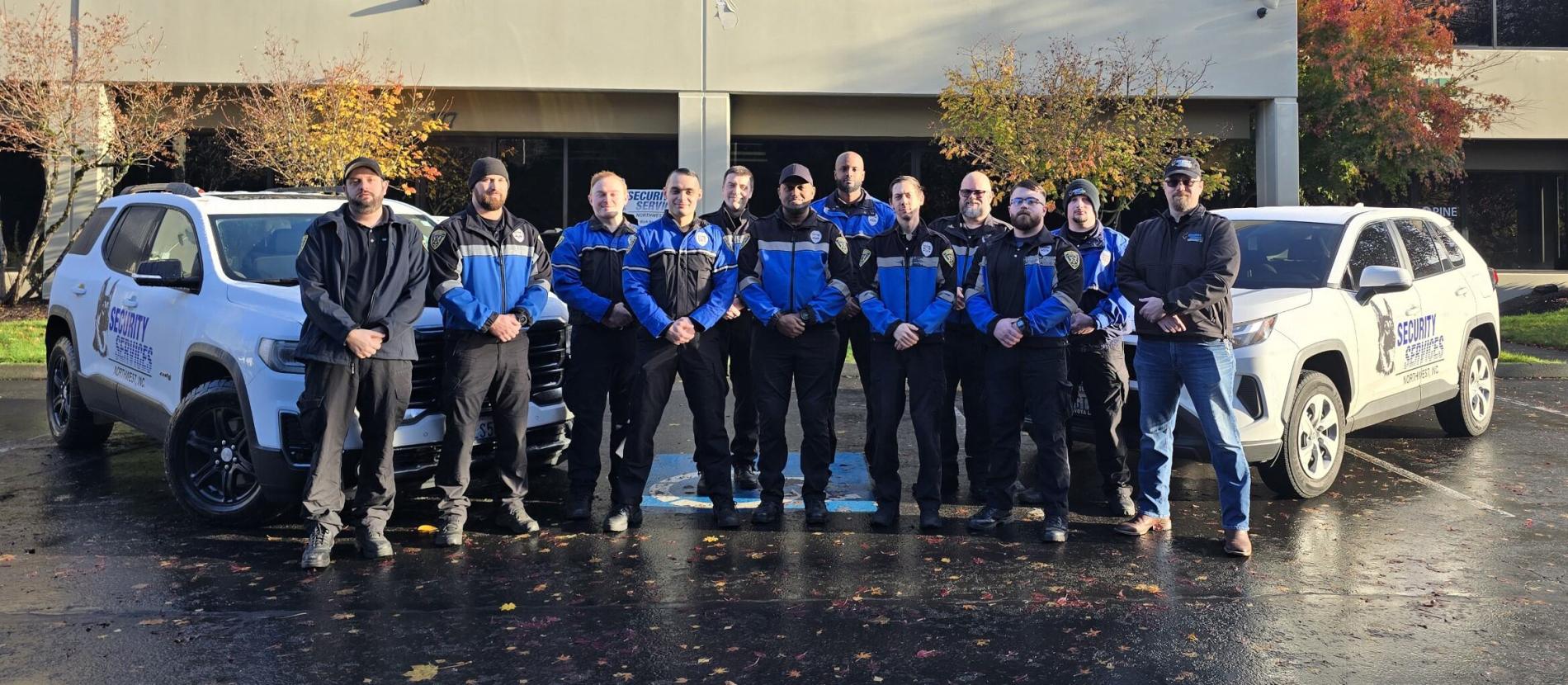 ssnw supervisors standing in front of two security patrol vehicles