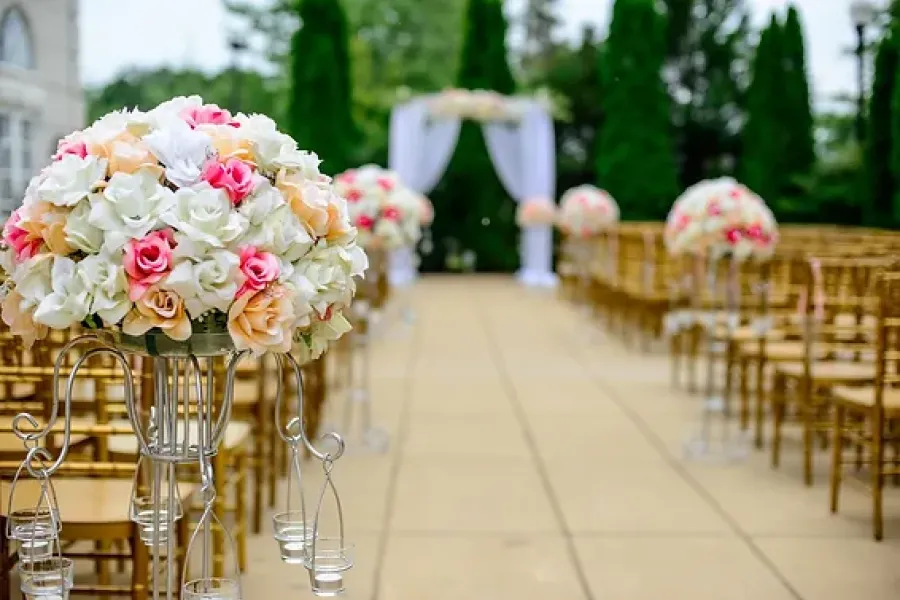 chairs and flowers set up for wedding ceremony; view of looking down aisle