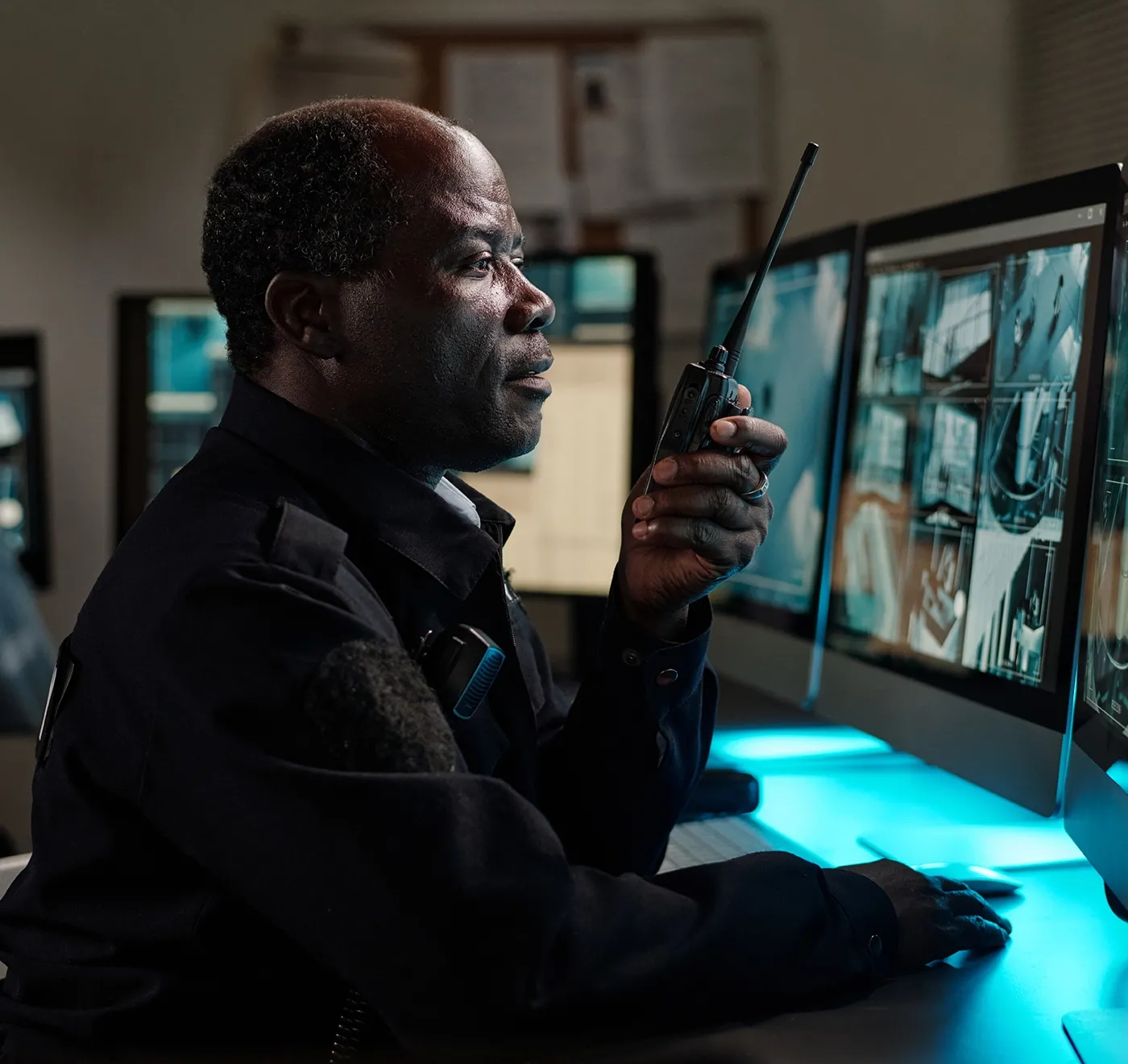 Officer talking on radio while viewing security cameras